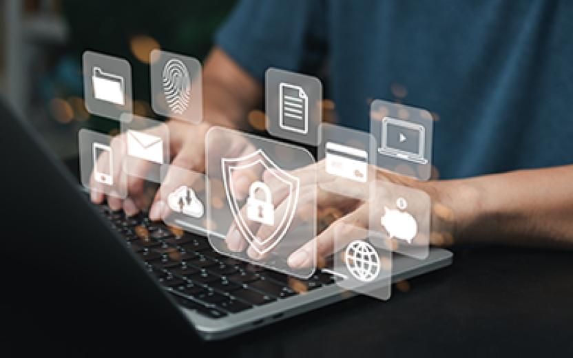 photo illustration hands on computer keyboard with security icons